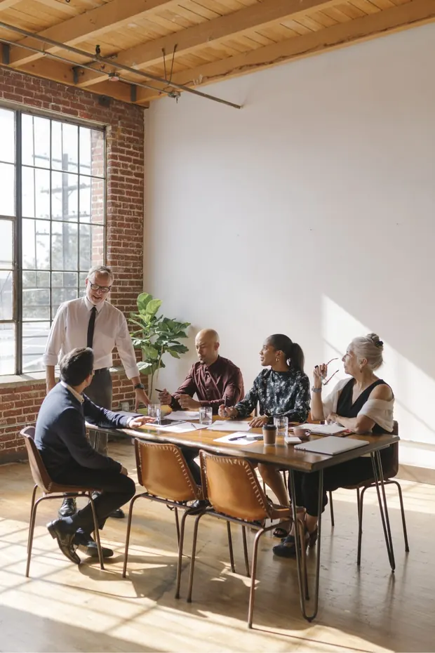 An S4 accountant leading a strategy meeting with a client team around a boardroom table
