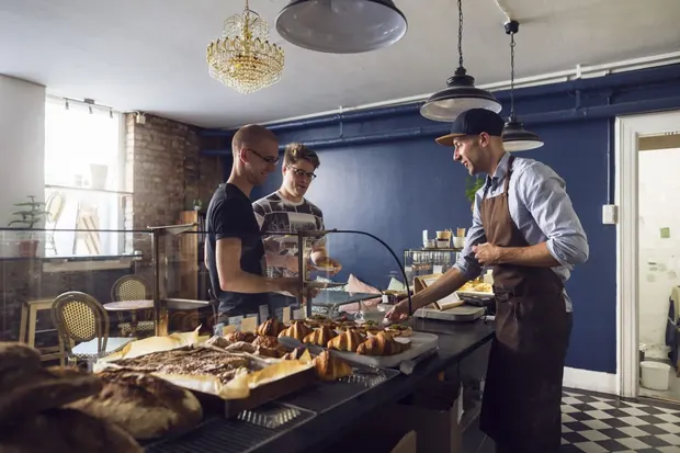 Two small-business owners reviewing stock in their workshop